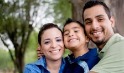 Photo of a young boy hugging his mother and father.